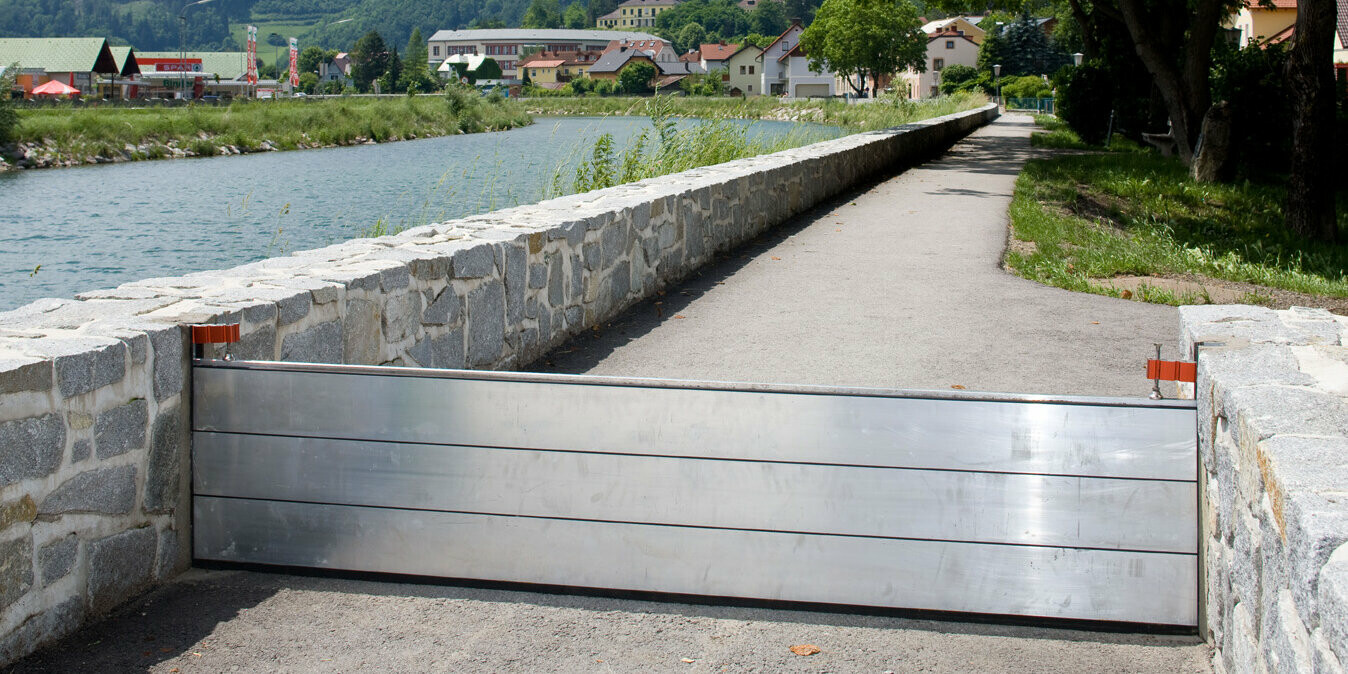 Aufgebauter PREFA Hochwasserschutz neben einem Fluss