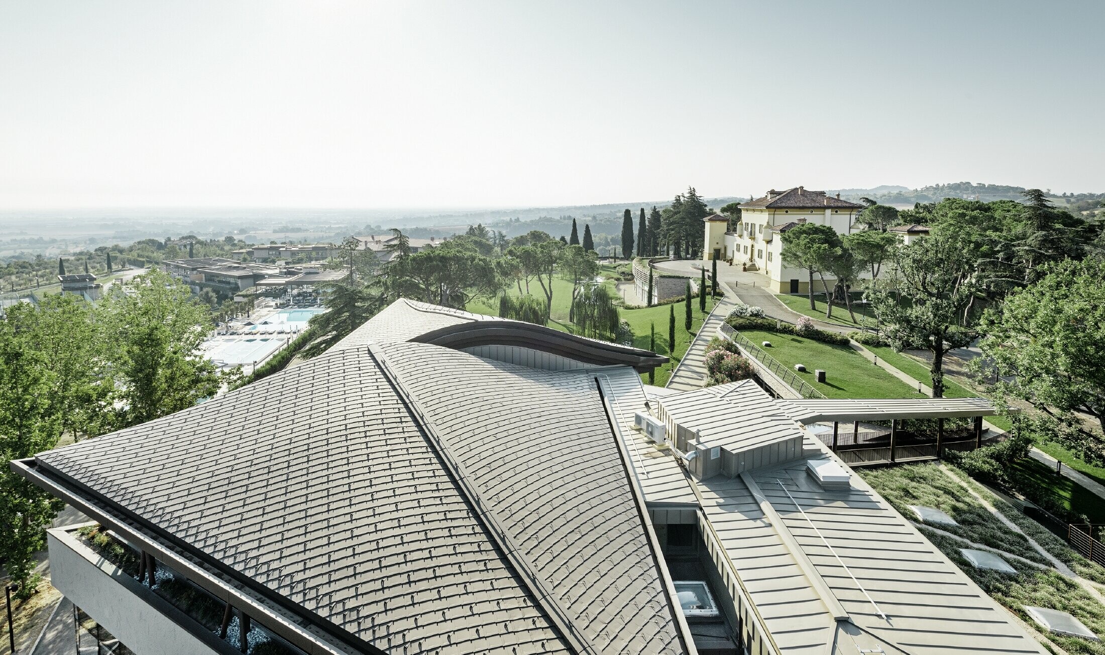 Palazzo del Golf Resort Varignana con una copertura estesa in alluminio PREFA in marrone