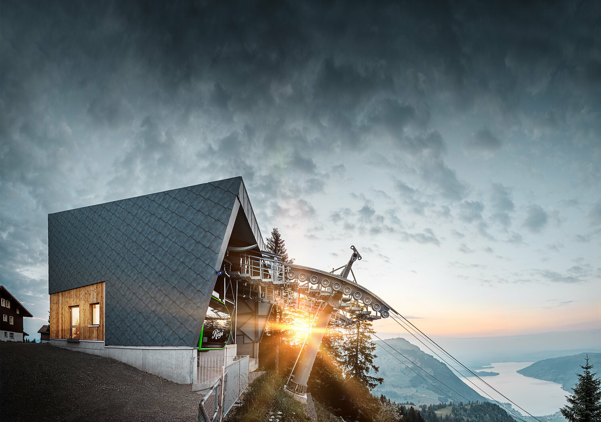 Stazione a monte della funivia Rigi Scheidegg al tramonto. La stazione a monte recentemente ristrutturata è stata rivestita con la scaglia 44 x 44 PREFA in P.10 grigio pietra.