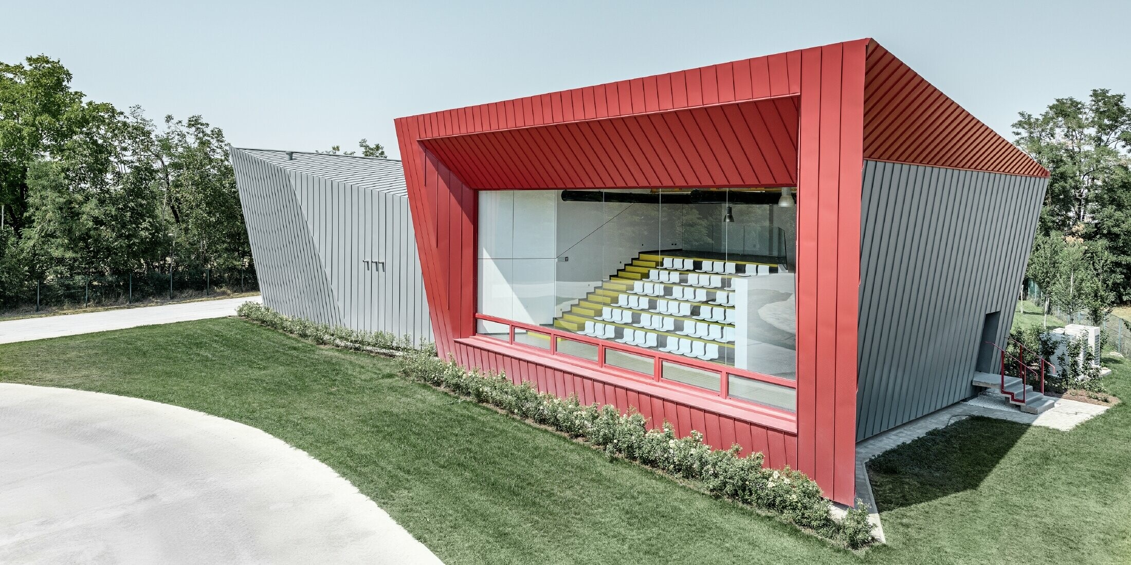 modernes Trainingscenter von Dieci in Montecchio Emilia ,Italien, mit Tribüne mit Aluminiumfassade mit Prefalz in hellgrau und Falzonal in karminrot 