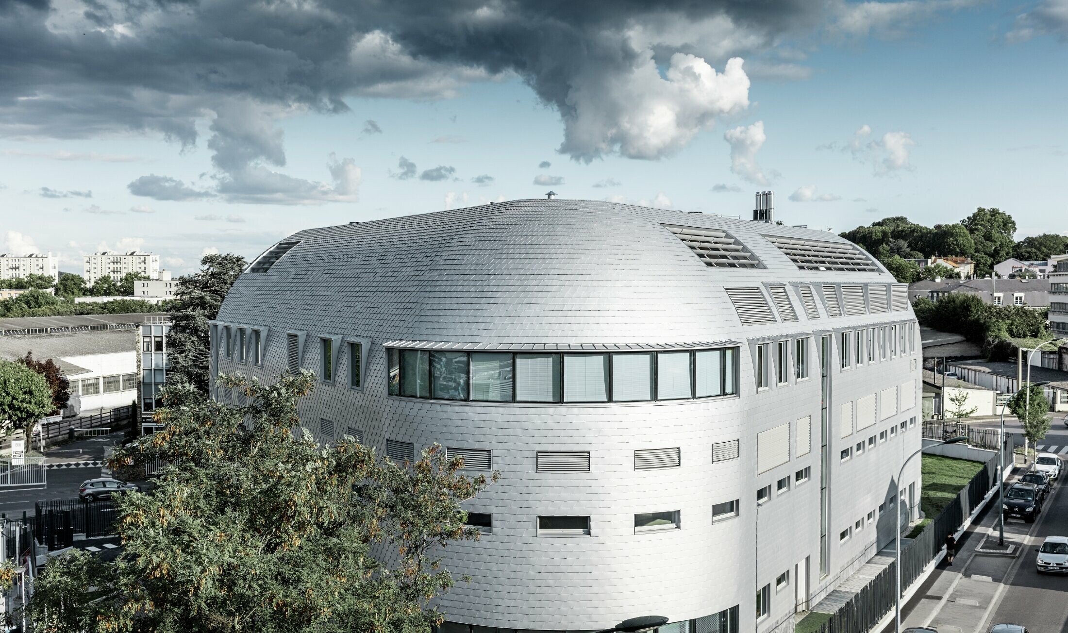 Edificio aziendale con cupola rotonda e scandole in alluminio PREFA rivestite in silver metallizzato;