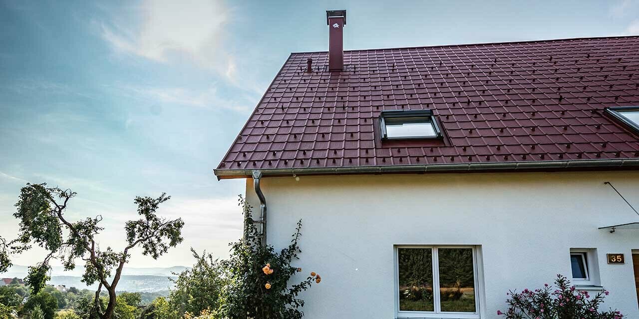 Häuschen am Land, neu saniertes Dach mit PREFA Dachplatte in Oxydrot, Dachfenster und Kamineinfassung.
