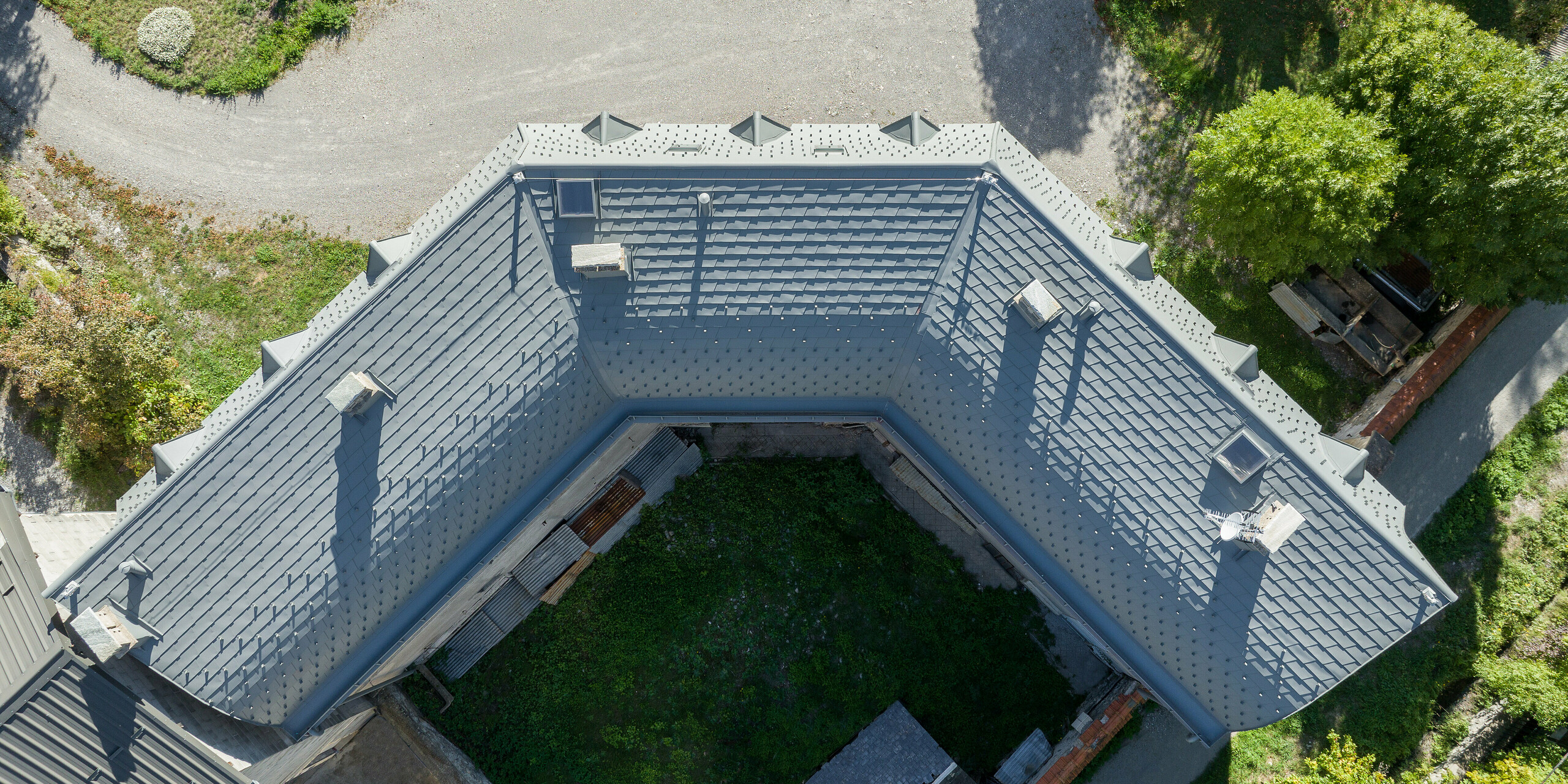 Die großflächige Dachlandschaft eines Anwesens in Barcelonnette, Frankreich wurde mit der PREFA Dachschindel in P.10 Hellgrau saniert. 