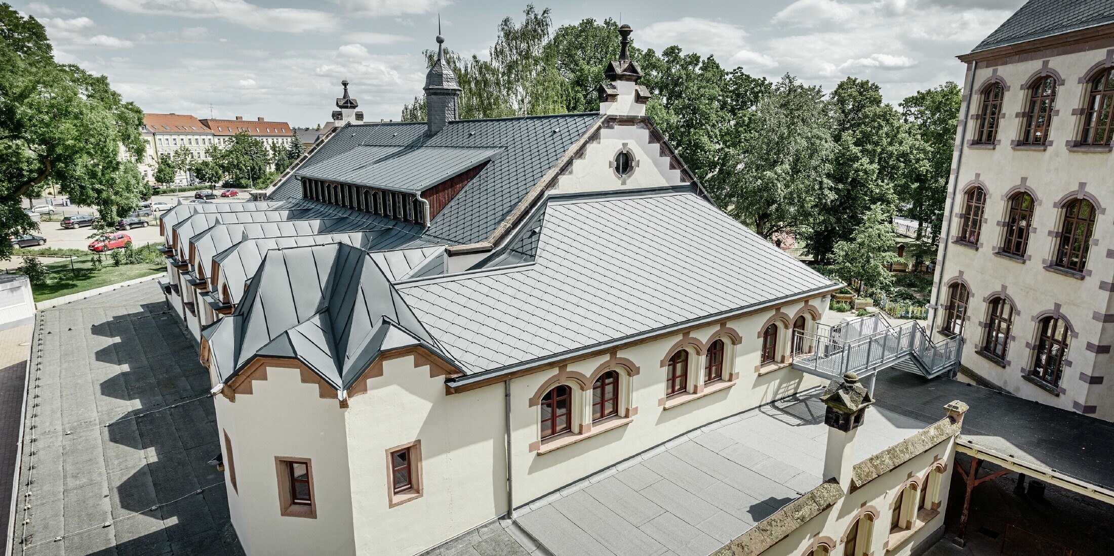 frisch sanierte Turnhallte der Schule Lutherstadt Wittenberg mit einem PREFA Aluminiumdach, verlegt wurden die Dachraute und Prefalz in anthrazit