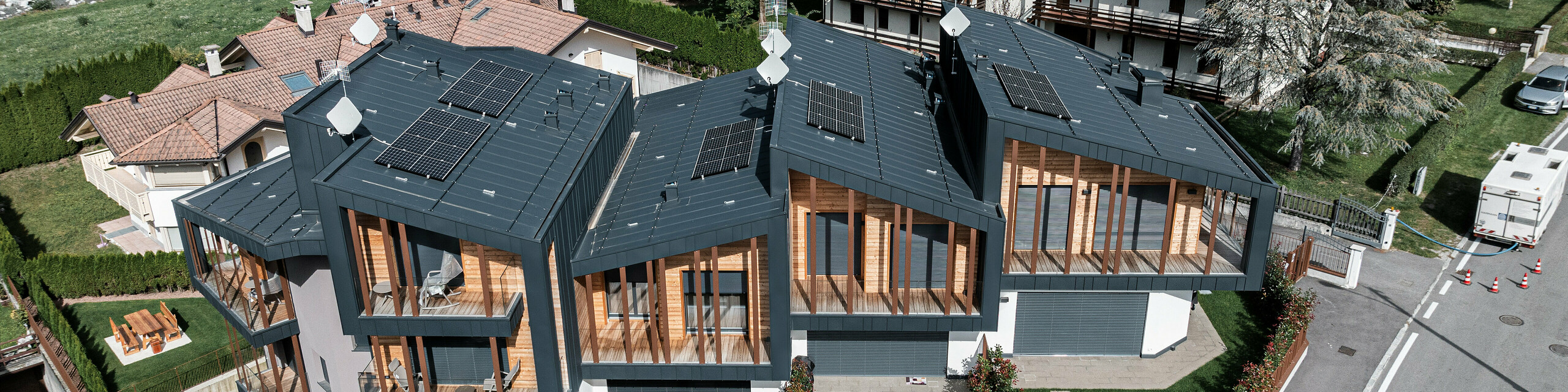 Ripresa dall'alto dei Calet Vette del Brenta a Pinzolo con copertura e facciata in Prefalz antracite.