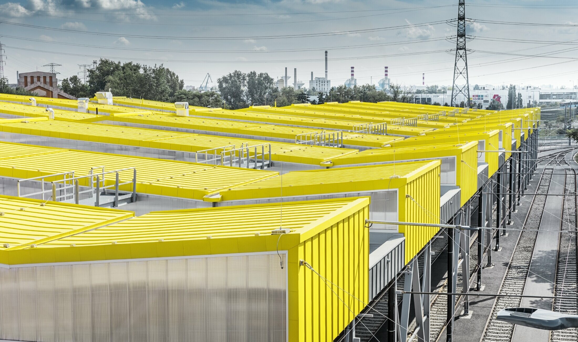 La forma della nuova Remise di Budapest ricorda i tram della città stessa. Sono stati rivestiti da un tetto con aggraffatura di PREFA di colore giallo traffico, RAL 1023.