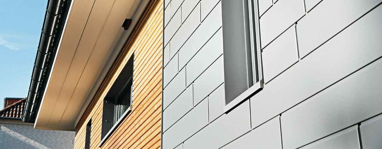 Kombination von Aluminiumg - PREFA Siding in Graualuminium - mit einer Holzfassade. Horizontale Verlegung, versetzte Fugen.