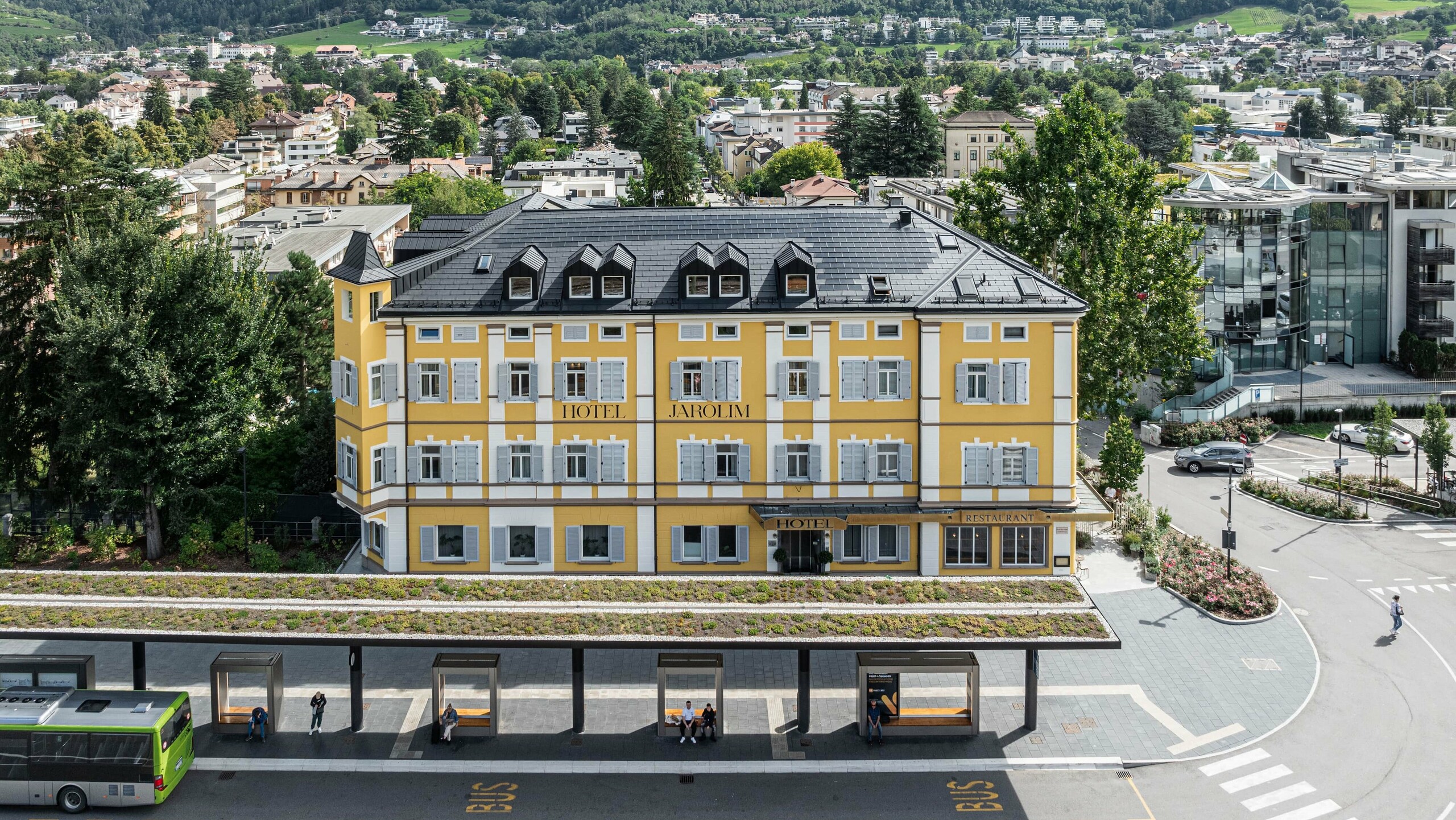 Vista dall'alto dello storico Hotel Jarolim ristrutturato in tegole fotovoltaiche PREFA a Bressanone.