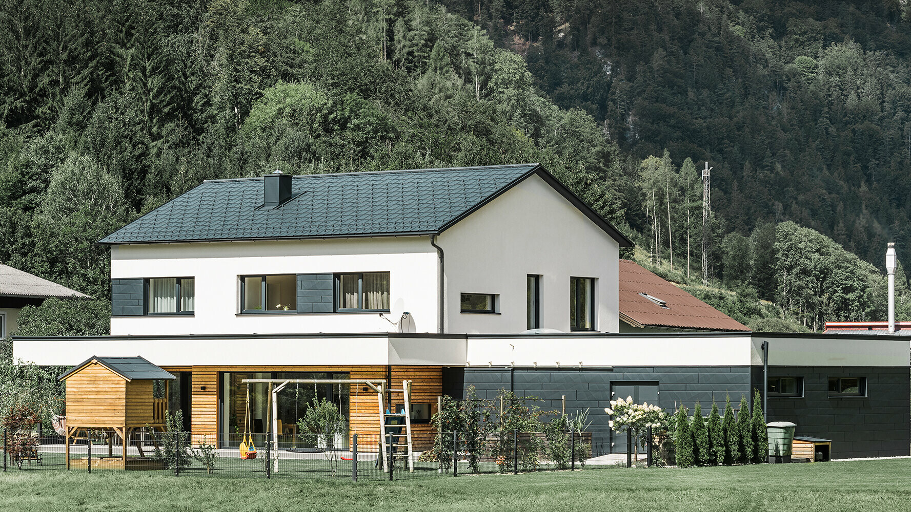 Casa unifamiliare di nuova costruzione con facciata in legno di larice in combinazione con Doga.X PREFA in antracite.