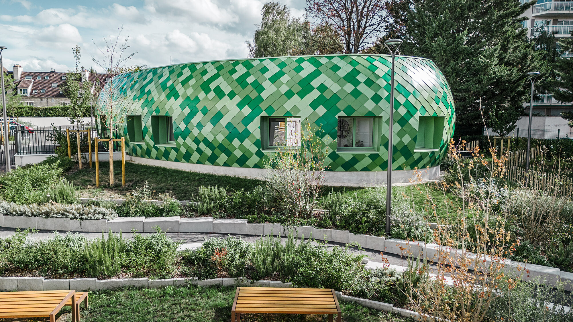 Blick auf das medizintherapeutische Zentrum, das die Grüntöne des umliegenden Parks farblich aufnimmt.