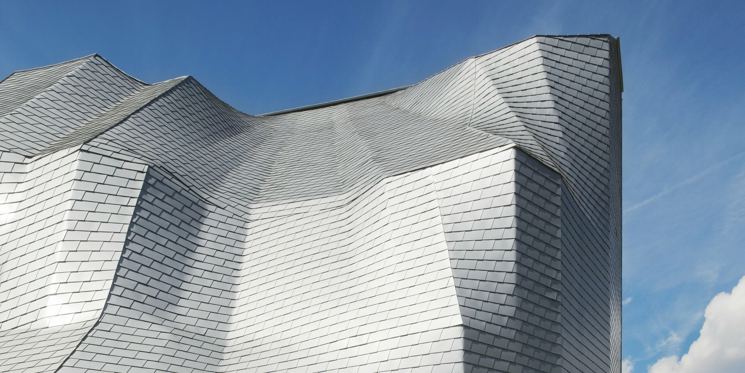 Rückseite Kletterturm mit auffälliger Gebäudehülle bestehend aus PREFA Dachschindeln Silbermetallic