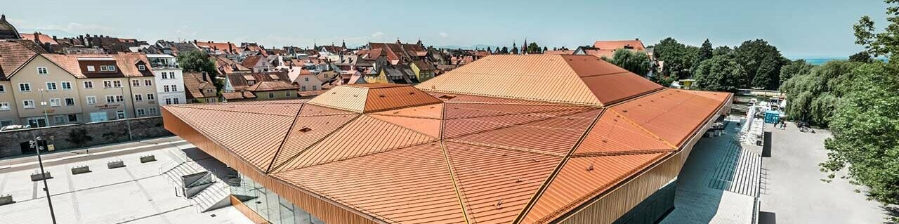 Centro congressi Lindau rivestito con PREFA Falzonal in marrone rosso.