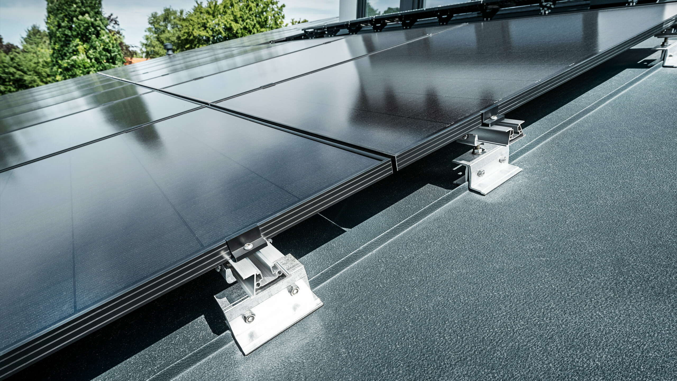 Primo piano della staffa solare PREFA PREFALZ Vario su un tetto ad aggraffatura verticale in antracite 