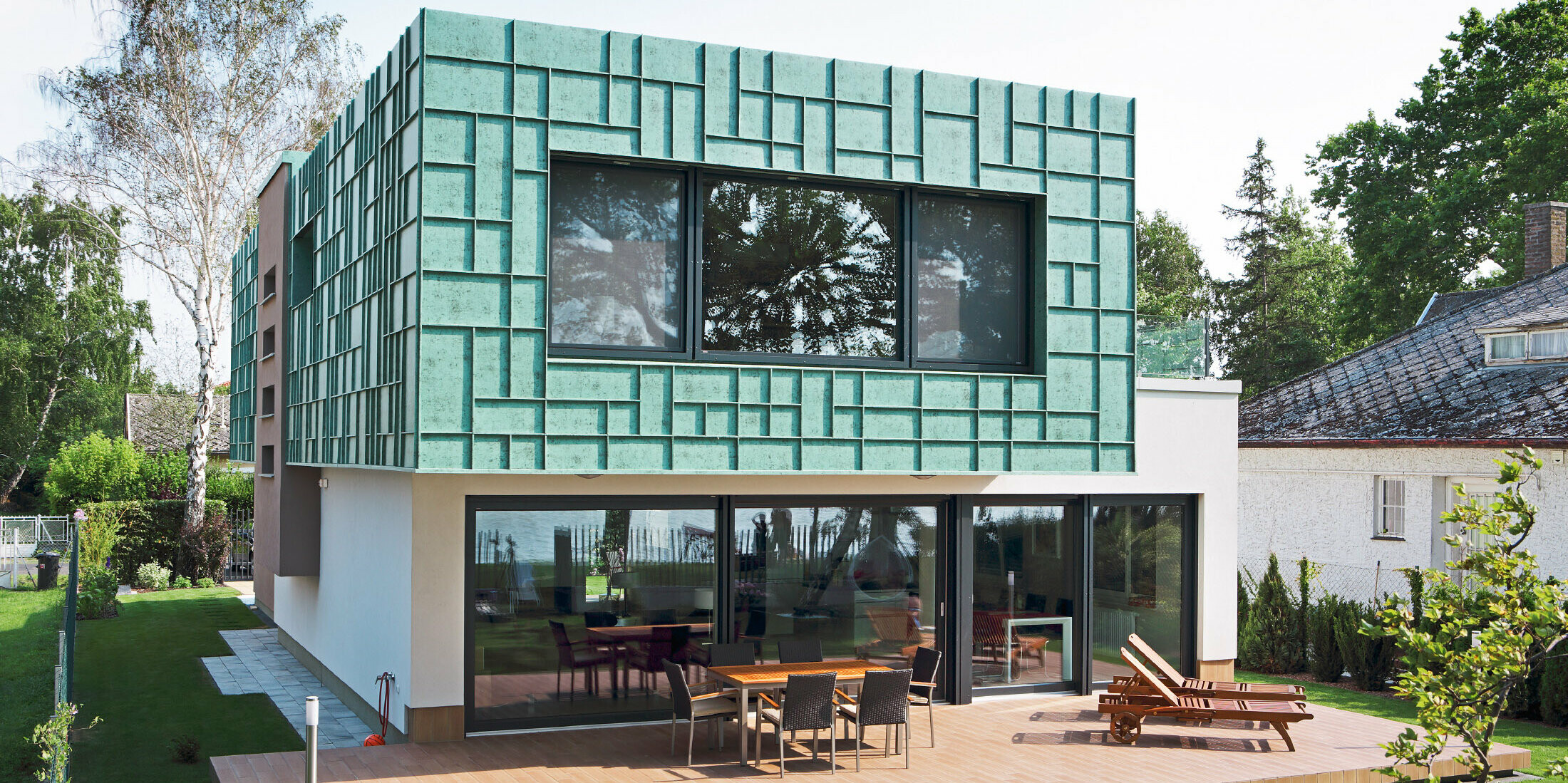 Modernes Einfamilienhaus mit sturmsicherer Fassade, die mit PREFALZ in P.10 Patina Grün verkleidet wurde.