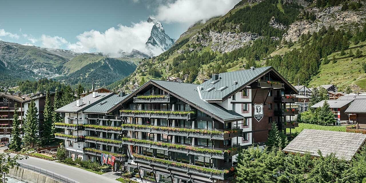 Hotelalpenhof a Zermatt con il Monte Cervino sullo sfondo, balconi, facciata in legno scura e una coperura in alluminio PREFA in antracite