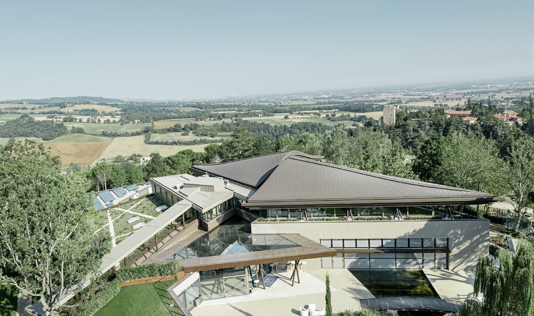 Palazzo del Golf Resort Varignana con una copertura estesa in alluminio PREFA in marrone