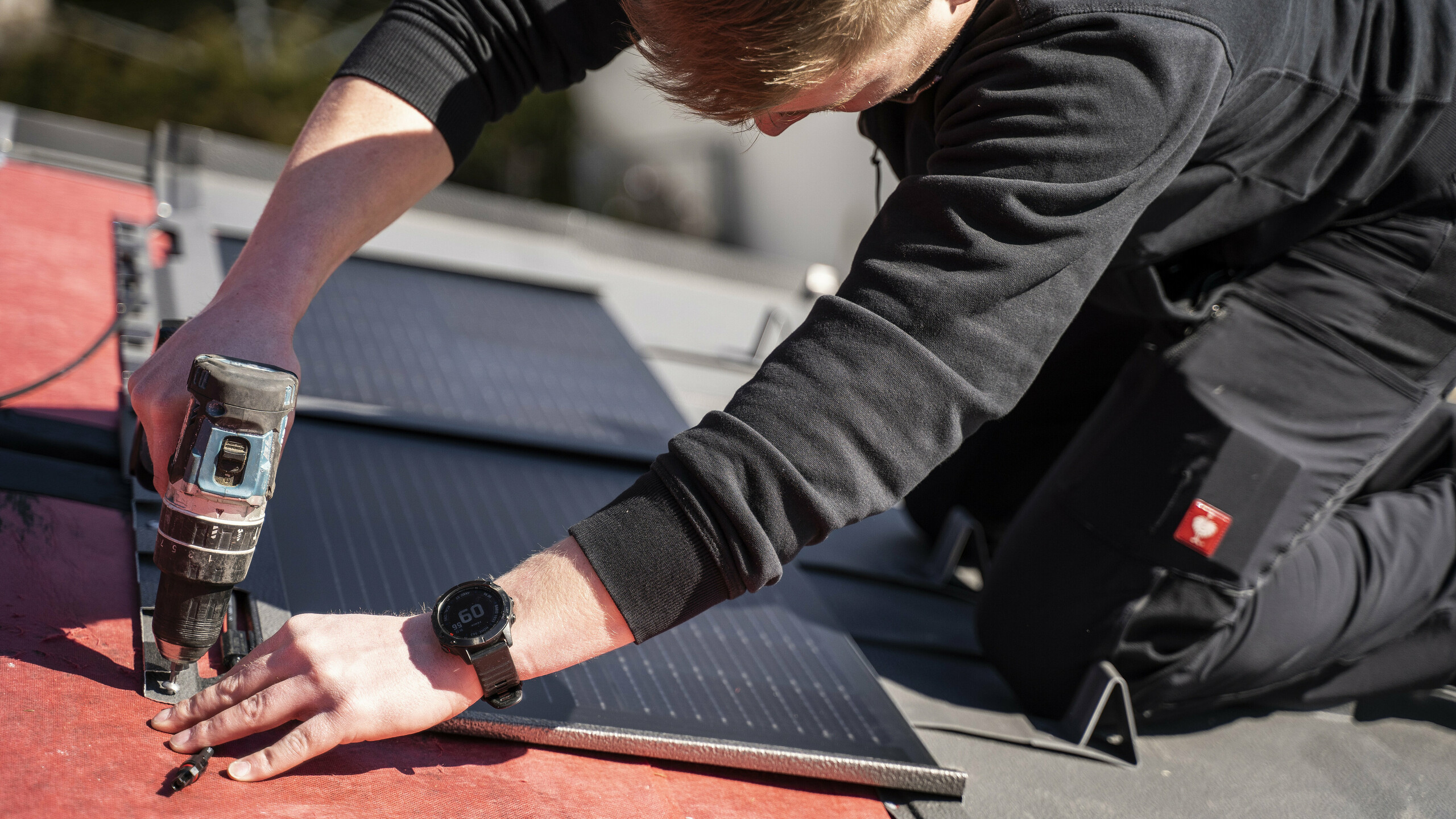 Un dipendente PREFA che posa la tegola fotovoltaica sul tetto.