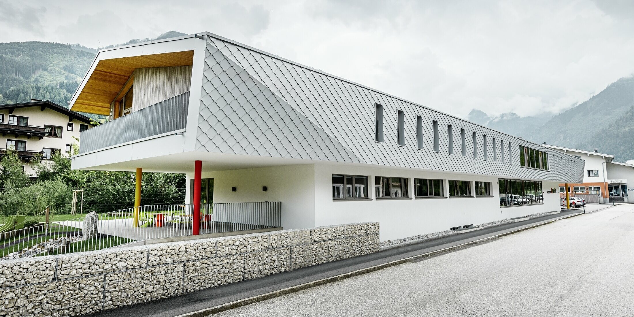 neu gebauter Kindergarten in Kaprun mit einer modernen Aluminium Fassade mit der PREFA Wandraute in prefaweiss