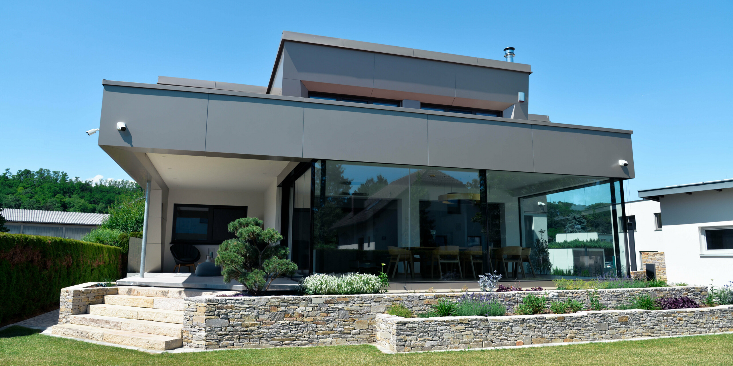 Garten und Terrasse eines Einfamilienhauses in Viehofen mit einer Gebäudehülle aus PREFA Aluminium